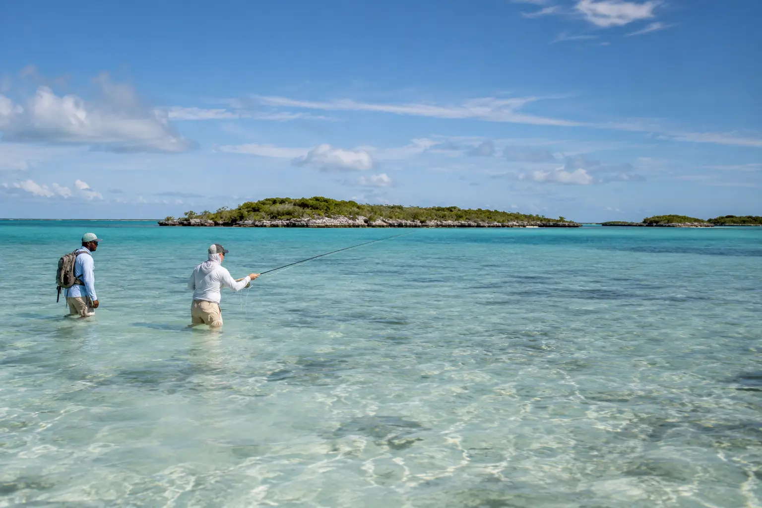 Two anglers wading a clear shallow flat in The Bahamas